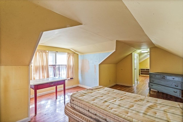 bedroom featuring vaulted ceiling, baseboards, and wood finished floors