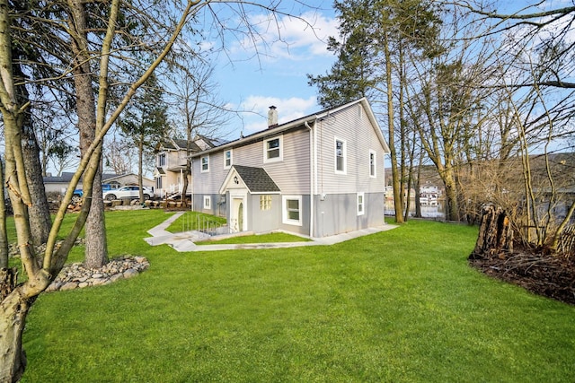 back of house featuring a lawn and a chimney