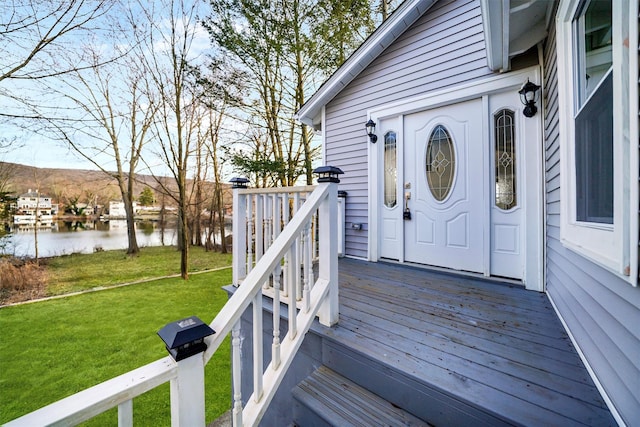 view of exterior entry with a yard and a water view