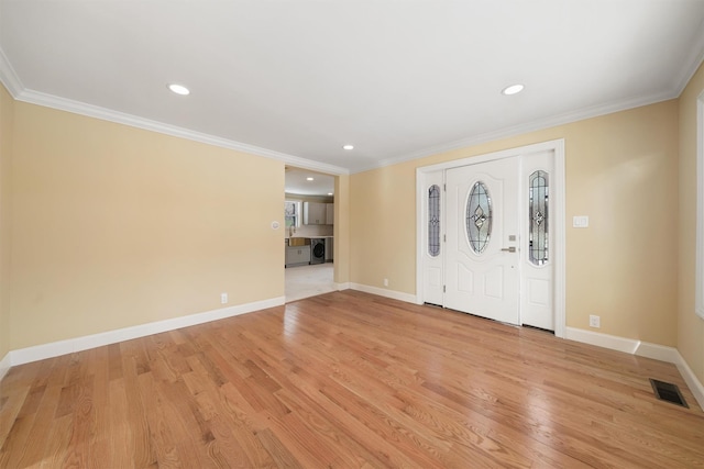 entryway with crown molding, light wood-style floors, visible vents, and baseboards