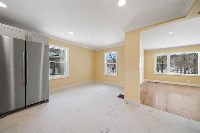 interior space featuring plenty of natural light, marble finish floor, and ornamental molding