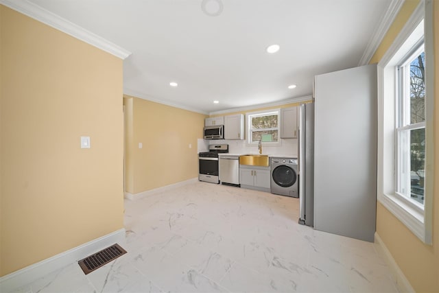 kitchen with visible vents, marble finish floor, a sink, washer / clothes dryer, and appliances with stainless steel finishes