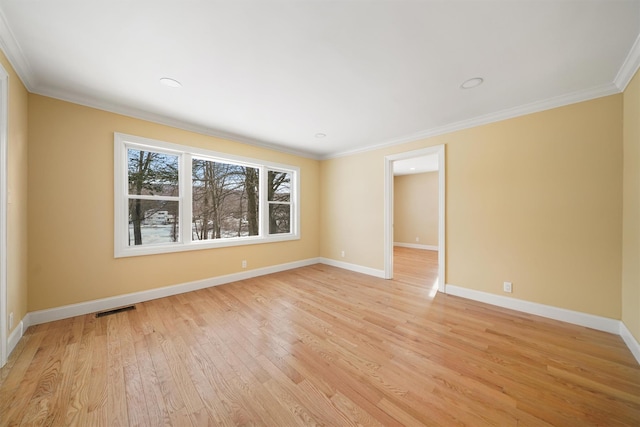 empty room featuring visible vents, baseboards, light wood-style flooring, and ornamental molding