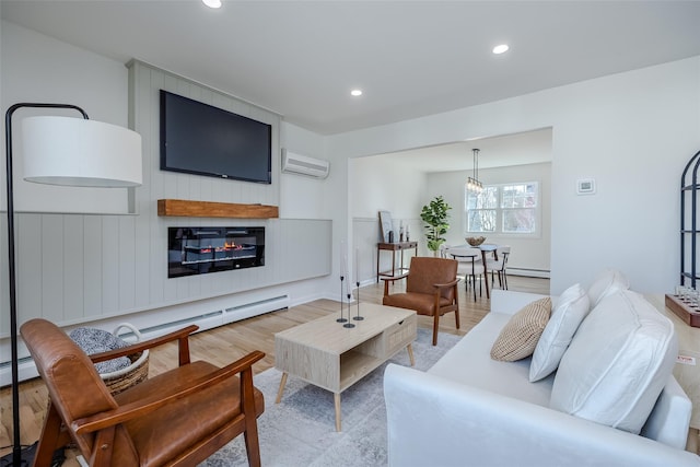 living room featuring a glass covered fireplace, recessed lighting, wood finished floors, and a wall mounted air conditioner