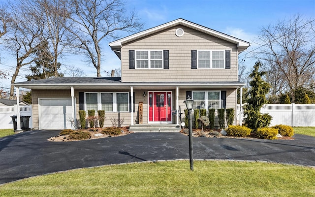 traditional home featuring fence, a garage, and driveway