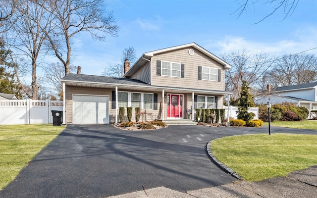 view of front of property featuring aphalt driveway, an attached garage, a front lawn, and fence