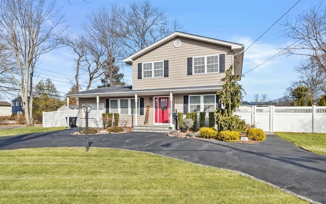 view of front of property with driveway, a front yard, and fence