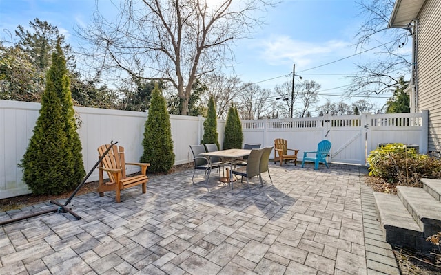 view of patio / terrace featuring outdoor dining area, a fenced backyard, and a gate