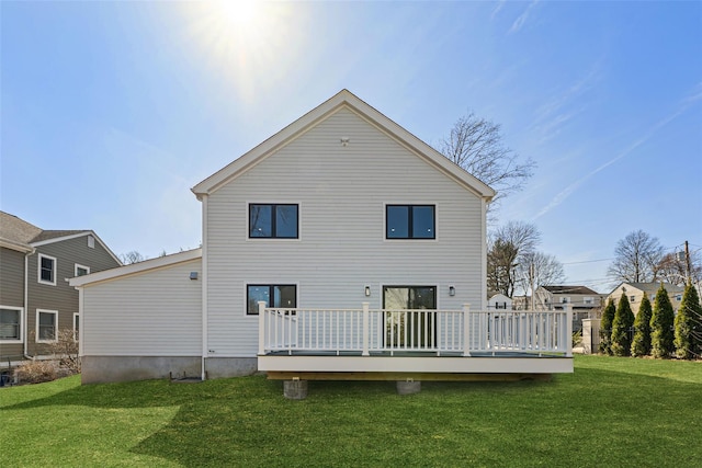 rear view of property featuring a lawn and a deck