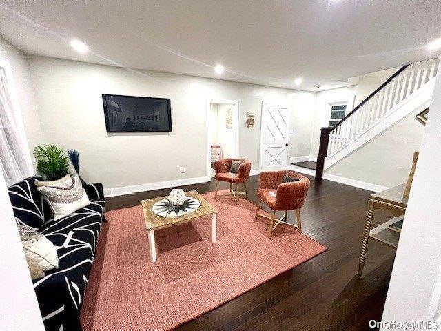 living area with stairs, recessed lighting, wood finished floors, and baseboards