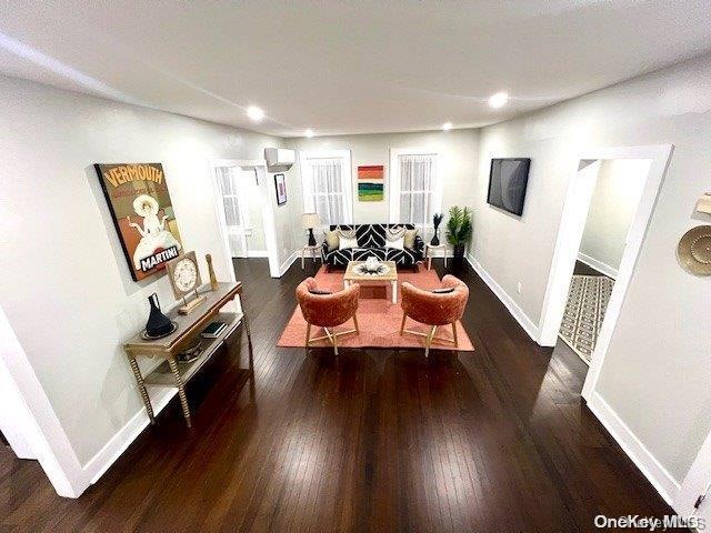 living room featuring dark wood-type flooring and baseboards