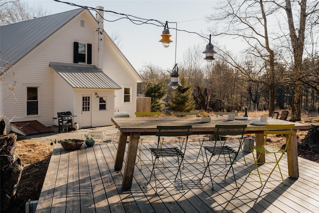 deck featuring outdoor dining area and a grill