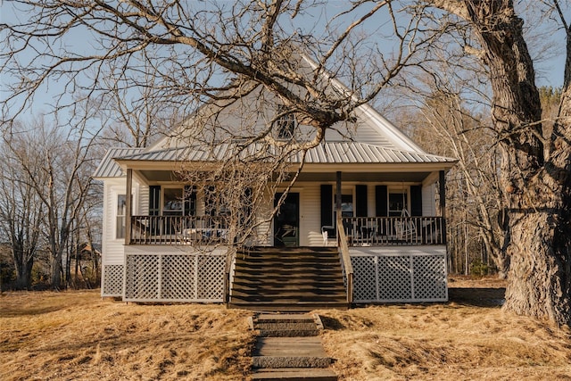 view of front of property with stairway, a porch, and metal roof