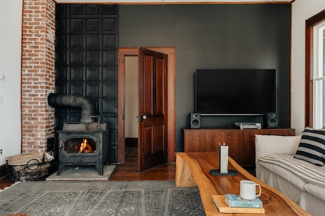 living room featuring a wood stove and wood finished floors