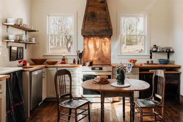 kitchen with dark wood finished floors, dishwasher, range, and premium range hood