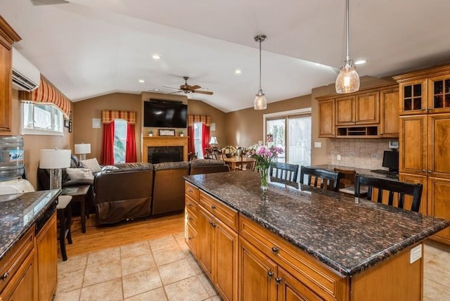 kitchen with lofted ceiling, a kitchen island, brown cabinetry, and a wall mounted AC