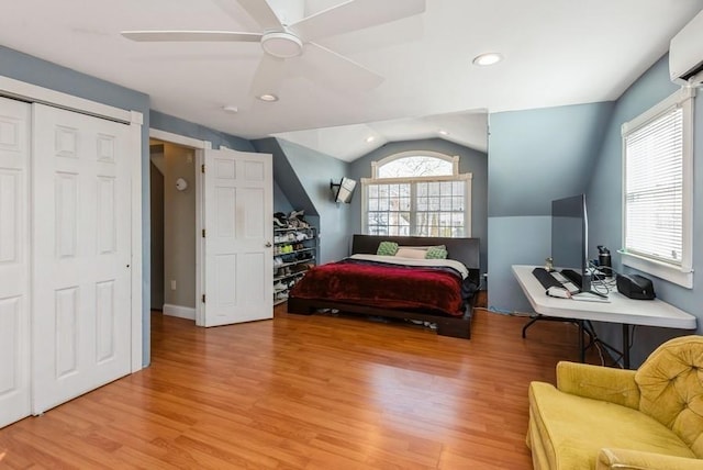 bedroom with a wall mounted air conditioner, recessed lighting, light wood finished floors, lofted ceiling, and ceiling fan