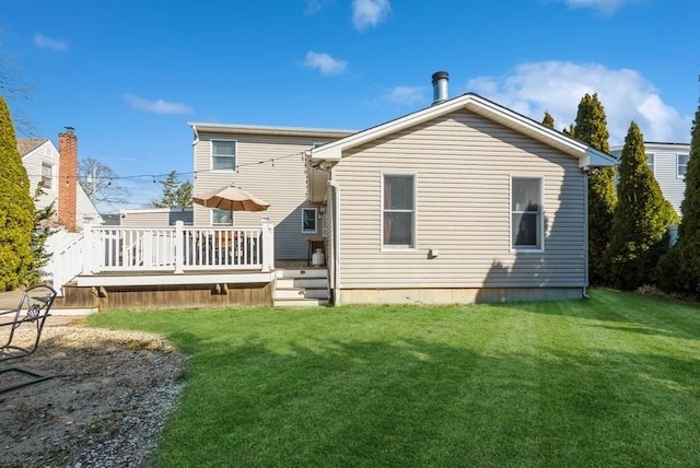 rear view of property with a yard and a wooden deck