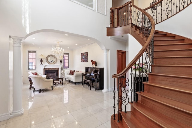 tiled foyer with arched walkways, crown molding, and ornate columns