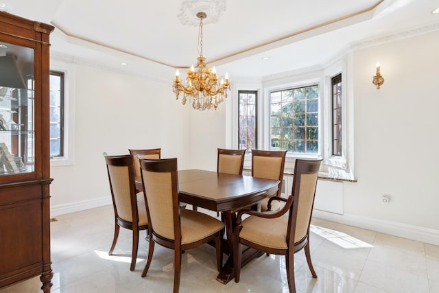 dining area featuring a tray ceiling, a healthy amount of sunlight, baseboards, and a chandelier