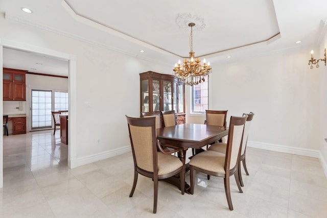 dining area with a raised ceiling, ornamental molding, recessed lighting, an inviting chandelier, and baseboards