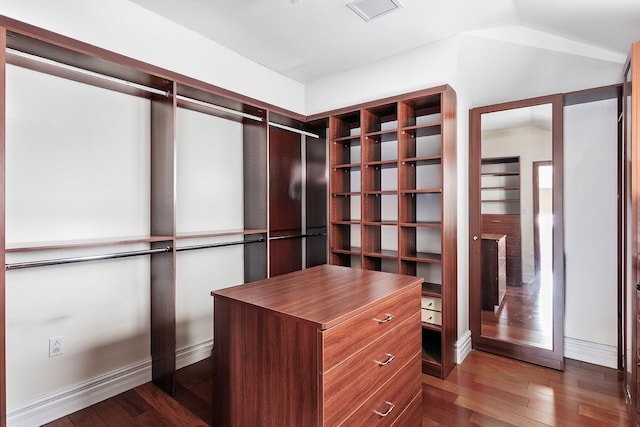 walk in closet featuring visible vents, dark wood-type flooring, and vaulted ceiling