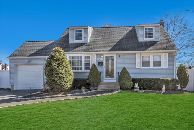 view of front of property featuring a garage, a front yard, and a shingled roof