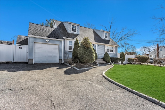 view of front of property with a front lawn, fence, roof with shingles, driveway, and an attached garage