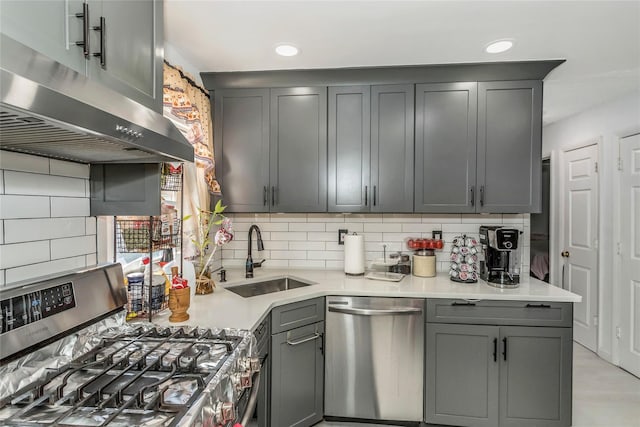 kitchen with a sink, backsplash, appliances with stainless steel finishes, and under cabinet range hood