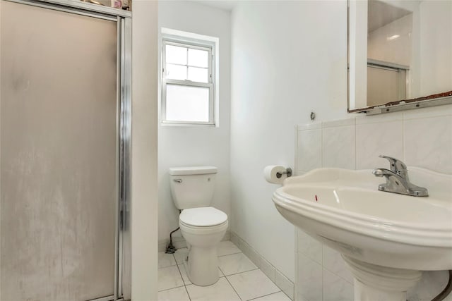 bathroom featuring toilet, a stall shower, backsplash, tile patterned flooring, and baseboards