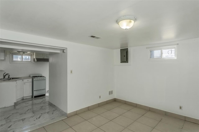 basement with electric panel, baseboards, visible vents, and a sink