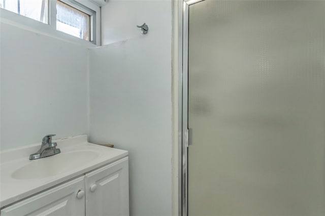 bathroom featuring vanity and a shower with door