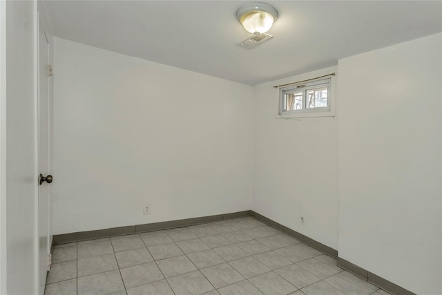 unfurnished room featuring light tile patterned floors, visible vents, and baseboards