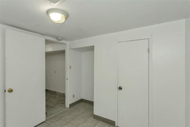 unfurnished bedroom with visible vents, marble finish floor, and baseboards