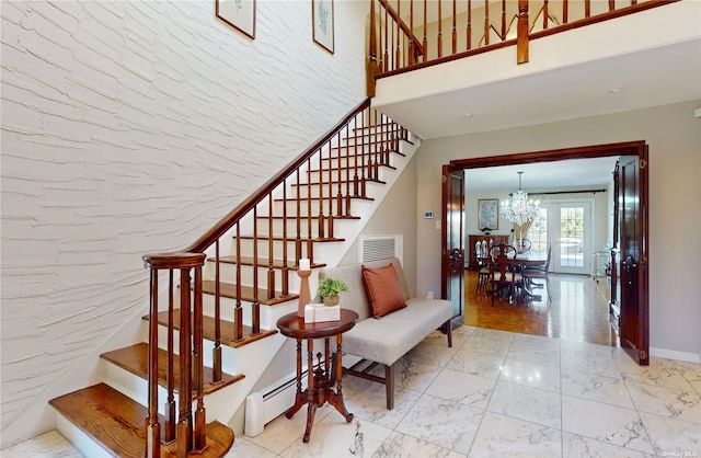 stairs with baseboards, visible vents, a baseboard radiator, a notable chandelier, and marble finish floor