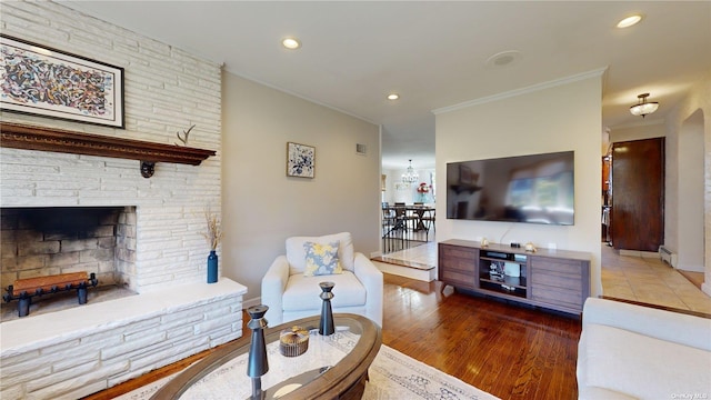 living room with recessed lighting, a baseboard heating unit, crown molding, and wood finished floors