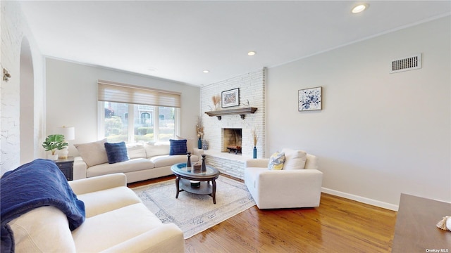 living room with visible vents, wood finished floors, recessed lighting, a fireplace, and baseboards