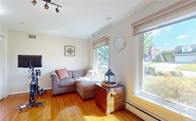 interior space with visible vents, wood finished floors, crown molding, and a baseboard radiator