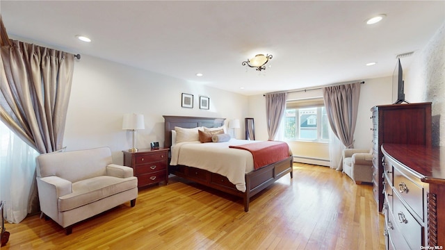 bedroom featuring recessed lighting, baseboard heating, and light wood finished floors