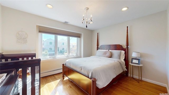 bedroom featuring an inviting chandelier, recessed lighting, light wood-type flooring, and baseboard heating