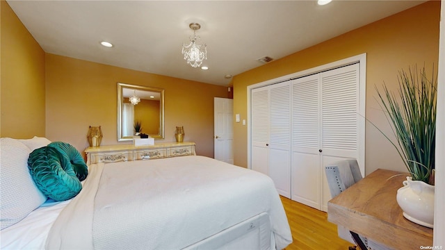 bedroom featuring light wood-type flooring, visible vents, recessed lighting, a closet, and a chandelier