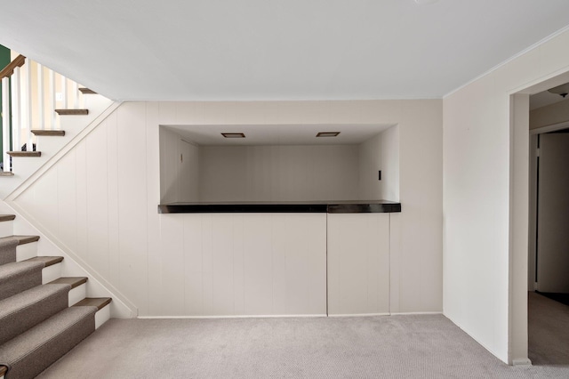 interior space with stairway, carpet, and crown molding