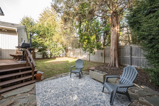 view of patio / terrace featuring a grill, a wooden deck, and a fenced backyard