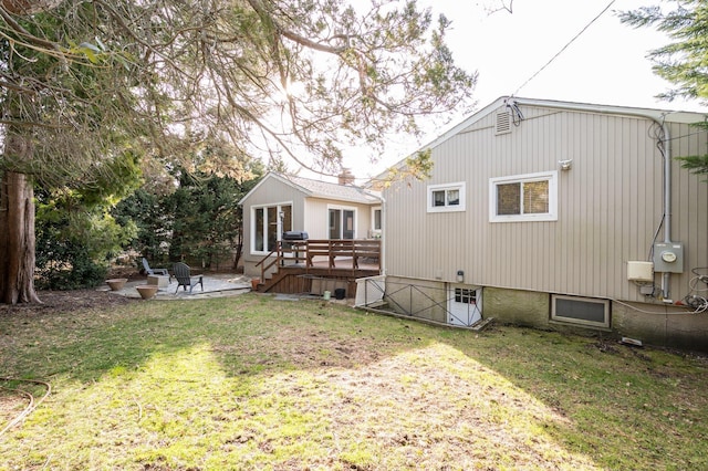 back of house featuring a patio, a lawn, and a deck