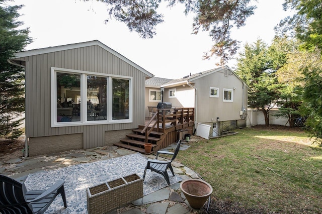 back of house featuring a patio area, a lawn, and a wooden deck