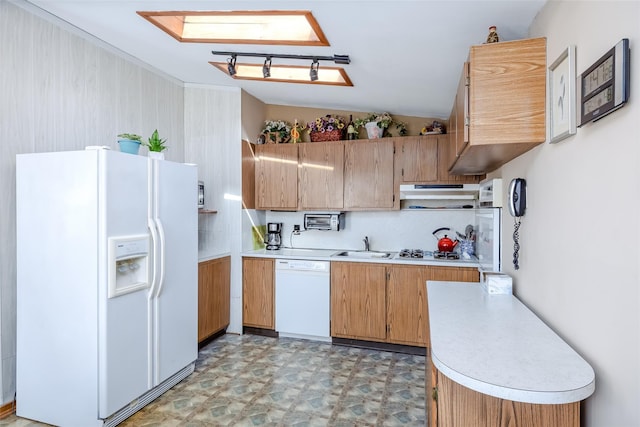 kitchen with under cabinet range hood, light floors, light countertops, lofted ceiling, and white appliances