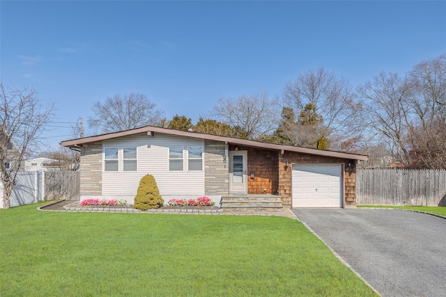 view of front of home featuring aphalt driveway, an attached garage, a front yard, and fence