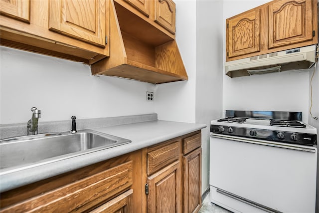 kitchen with under cabinet range hood, a sink, white gas range oven, brown cabinetry, and light countertops