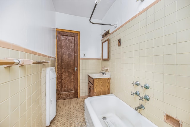 bathroom with vanity, tile walls, bathing tub / shower combination, and wainscoting