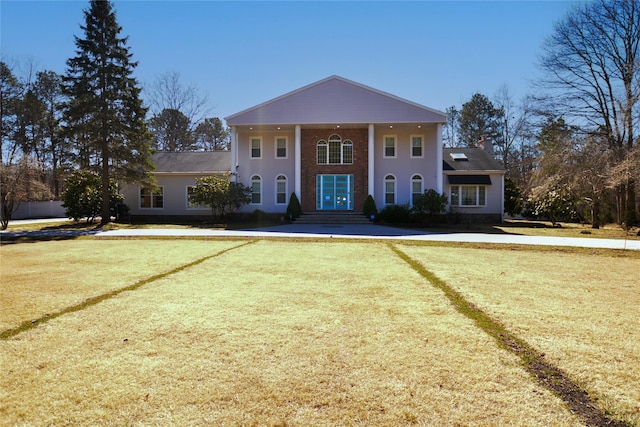 neoclassical / greek revival house featuring a front yard